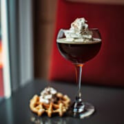 russian coffee in a red wine glass and a waffle beside it